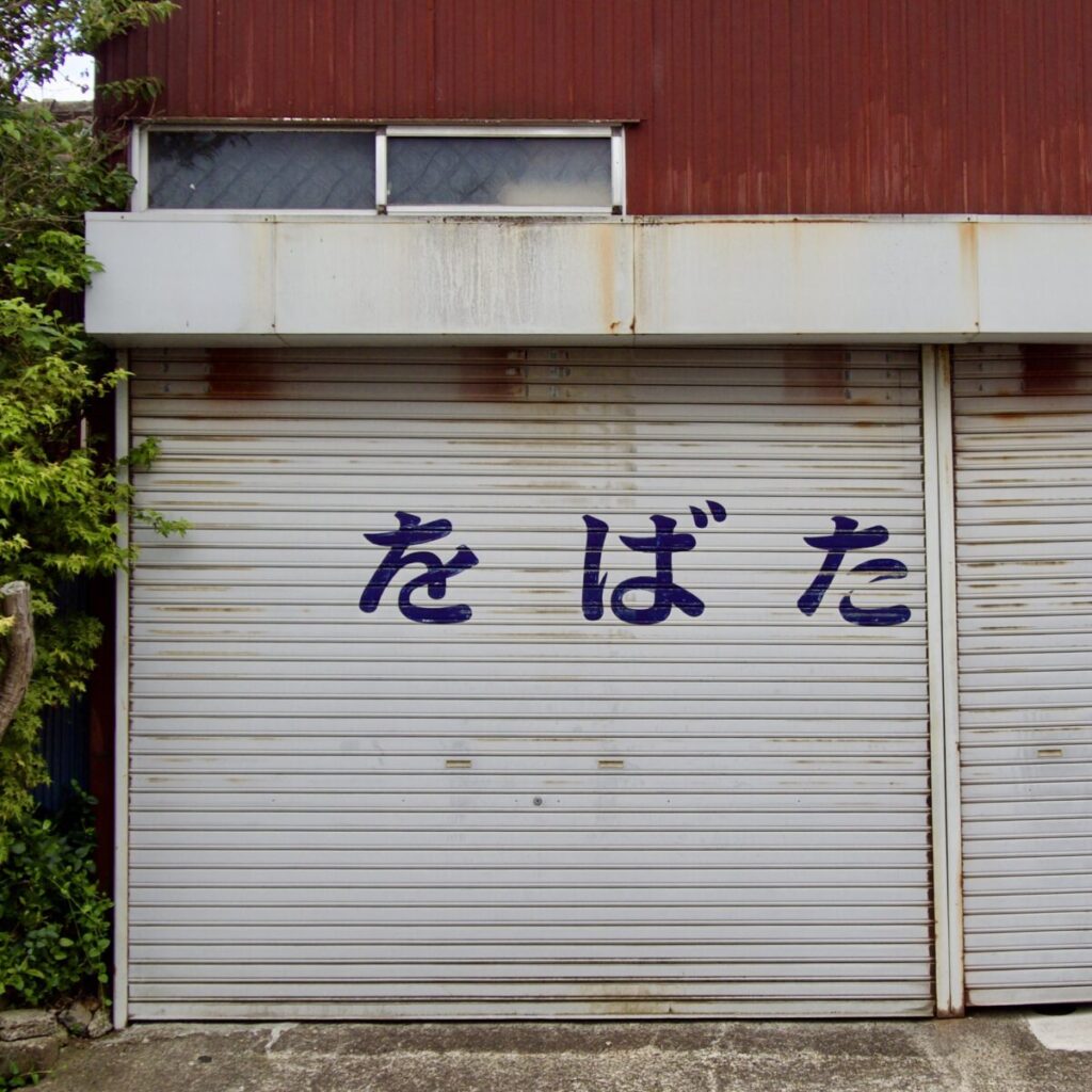 シャッターに「をばた」と大きく書かれたハミングロード513の商店