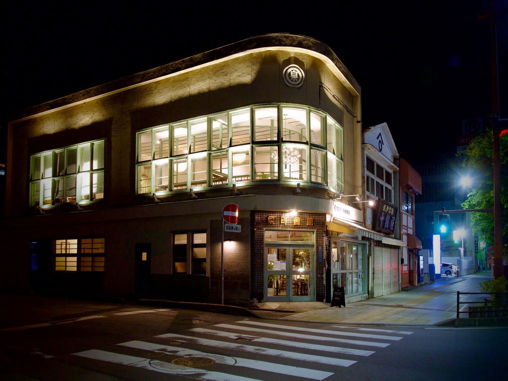 夜に窓の明かりが灯る泉町会館の外観