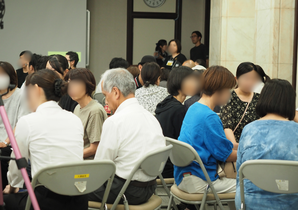 オモロー授業発表会in水戸の屋内の会場で椅子を輪にして座り語り合う人々